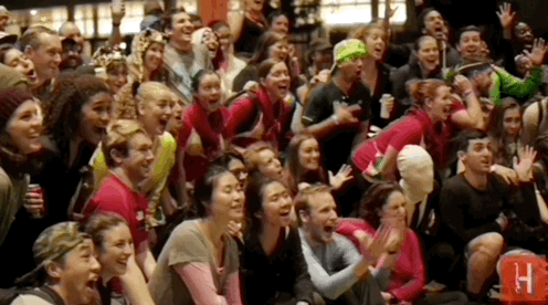 A group of people in costumes cheering.